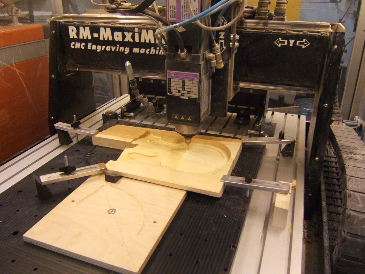 Computer numerical control machine carving a copy of a plate