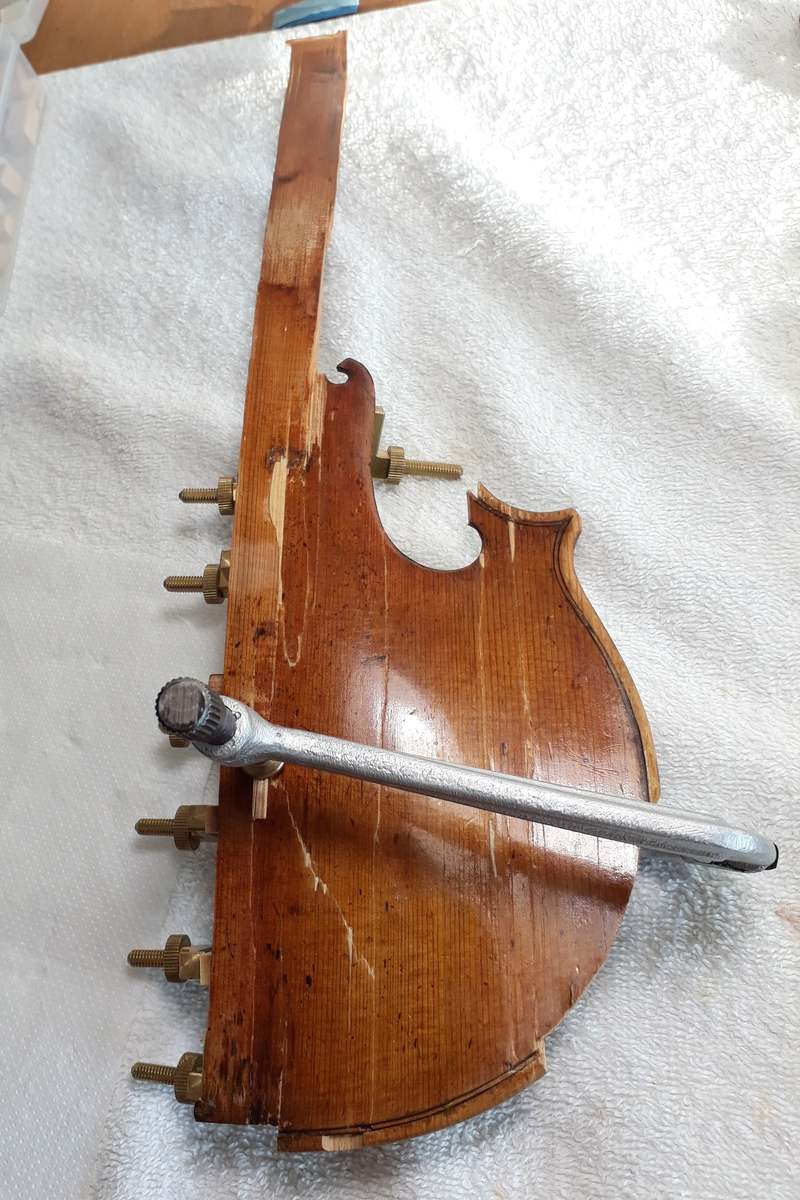 Old back held by clamps along a glued crack